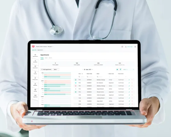 A doctor holding a laptop showing a plasma center appointments screen.